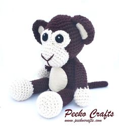 a crocheted monkey sitting on the ground with it's eyes wide open