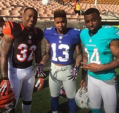 three football players posing for a photo on the field