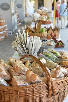 a basket full of food sitting on top of a table next to another basket filled with sandwiches