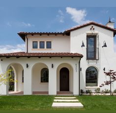 a white house with steps leading up to the front door and windows on each side