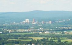 an aerial view of a city in the distance with mountains in the backgroud