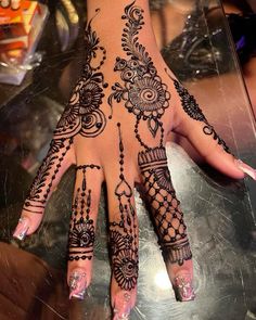 a woman's hand with henna tattoos on it