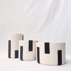 three black and white vases sitting next to each other