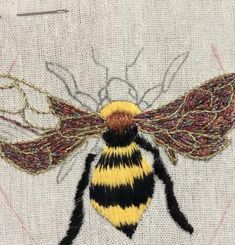 a yellow and black striped bee on white fabric