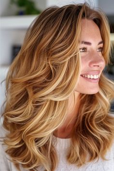 A rich blend of honey blonde and warm golden caramel tones create a vibrant, dimensional look. It’s styled in luxurious waves, giving a lively and sunkissed vibe. Click here to see more blond hair color ideas. Blonde Hair Color Honey, Warm Blonde Hair Color Honey, Highlights Curtain Bangs, Warm Blonde Hair Color, Blond Wavy Hair, Hair Color Honey, Warm Blonde Hair