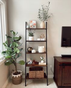 a living room filled with furniture and a flat screen tv on top of a wooden shelf