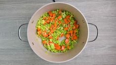 a pot filled with carrots and celery on top of a wooden table