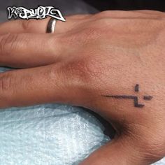 a person's hand with a cross tattoo on it