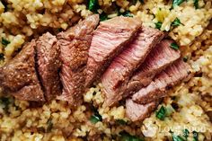 some meat and rice on a plate with spinach sprinkled around it's edges