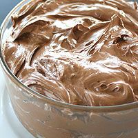 a bowl filled with chocolate frosting on top of a table