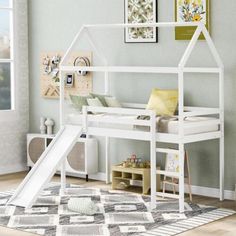 a child's bedroom with a white bunk bed and slide in front of it