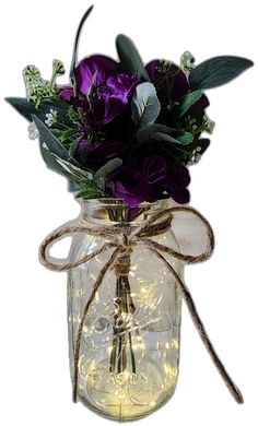 a mason jar filled with purple flowers and greenery wrapped in twine, on a white background