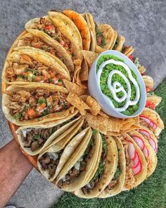 a platter filled with tacos, guacamole and other food items