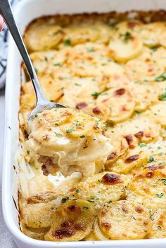 cheesy garlic scalloped potatoes in a casserole dish with a spoon