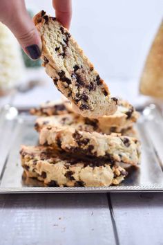 a person is picking up some cookies from a tray