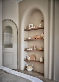 a bed sitting next to a wall with shelves on it