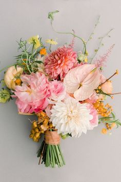 a bouquet of flowers sitting on top of a white wall next to a wooden frame