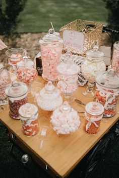 a table topped with lots of candy and candies on top of a wooden table