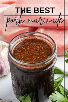 the best pork marinade in a mason jar with fresh herbs and garlic next to it