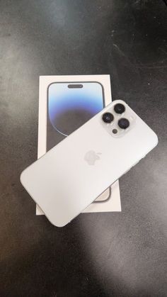 an apple iphone 11 pro with its box open on a table next to it's packaging