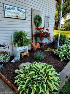 there is a garden with flowers and plants in the flower bed next to the building