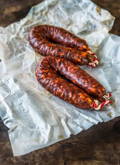 two sausages sitting on top of a piece of wax paper next to each other