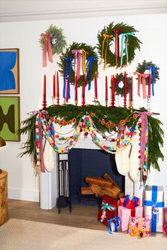 a fireplace decorated for christmas with stockings and candles