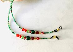 "Handmade eyeglass holder with a holiday feel with red and green glass beads, red crystal beads, silver toned spacers, and green seed beads.  The chain is 26 1/2\" long and should fit most eyeglasses or sunglasses." Red Eyeglasses, Eyeglass Holder, Eyeglass Chain, Glasses Chain, Eye Wear Glasses, Red Crystals, Eyewear Sunglasses, Green Glass, Womens Bracelets