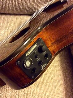 an acoustic guitar laying on top of a couch