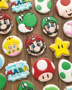 decorated cookies with mario and other characters are on a wooden table next to each other