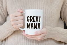 a woman holding a coffee mug with the words great mama printed on it in black