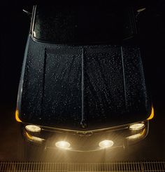 an overhead view of a car in the rain at night with its headlights turned on