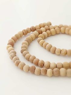 three wooden beads are arranged on a white surface