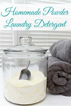 homemade powder laundry deterant in a glass jar next to two towels and a spoon