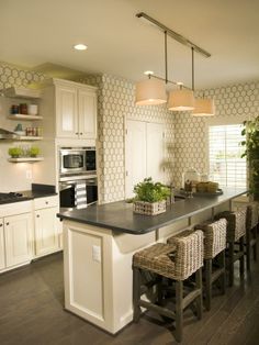 a kitchen with white cabinets and an island in front of a stove top oven next to a sink