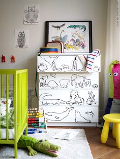 a child's room with green furniture and pictures on the wall