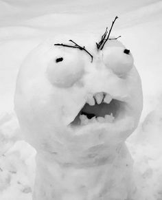 a snowman with its mouth open and eyes wide open in the middle of winter