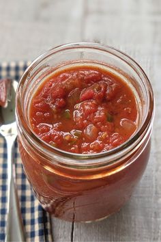 a glass jar filled with food sitting on top of a table next to a fork