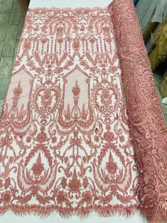 the table is covered with pink and white lace, which has an intricate design on it