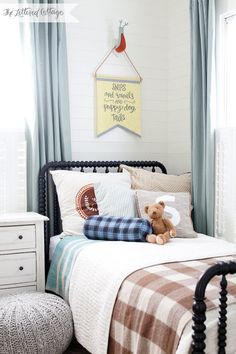 a bed room with a neatly made bed and a teddy bear