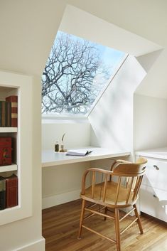 a chair sitting in front of a window next to a desk with books on it