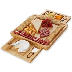 two cheeses, crackers, and meats on a cutting board next to a glass of wine