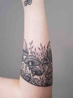 a woman's arm with a black and white tattoo design on the left side of her arm