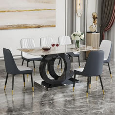 a dining room table with chairs and a painting on the wall in the back ground