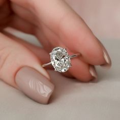 a woman's hand holding a diamond ring