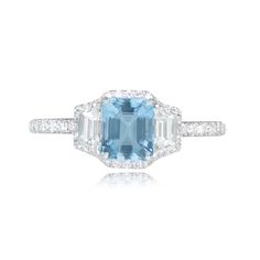 an aqua blue and white topazte ring with diamonds on the sides, set in 18k white gold