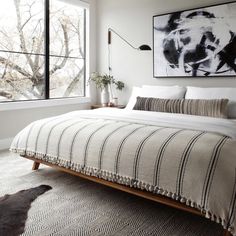 a bedroom with a large bed and two paintings on the wall above it's headboard