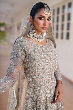 a woman in a bridal gown poses for the camera