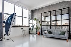 a living room filled with furniture next to large windows and a tv mounted on the wall