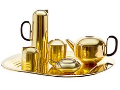 gold tea set with cups and saucers on a tray